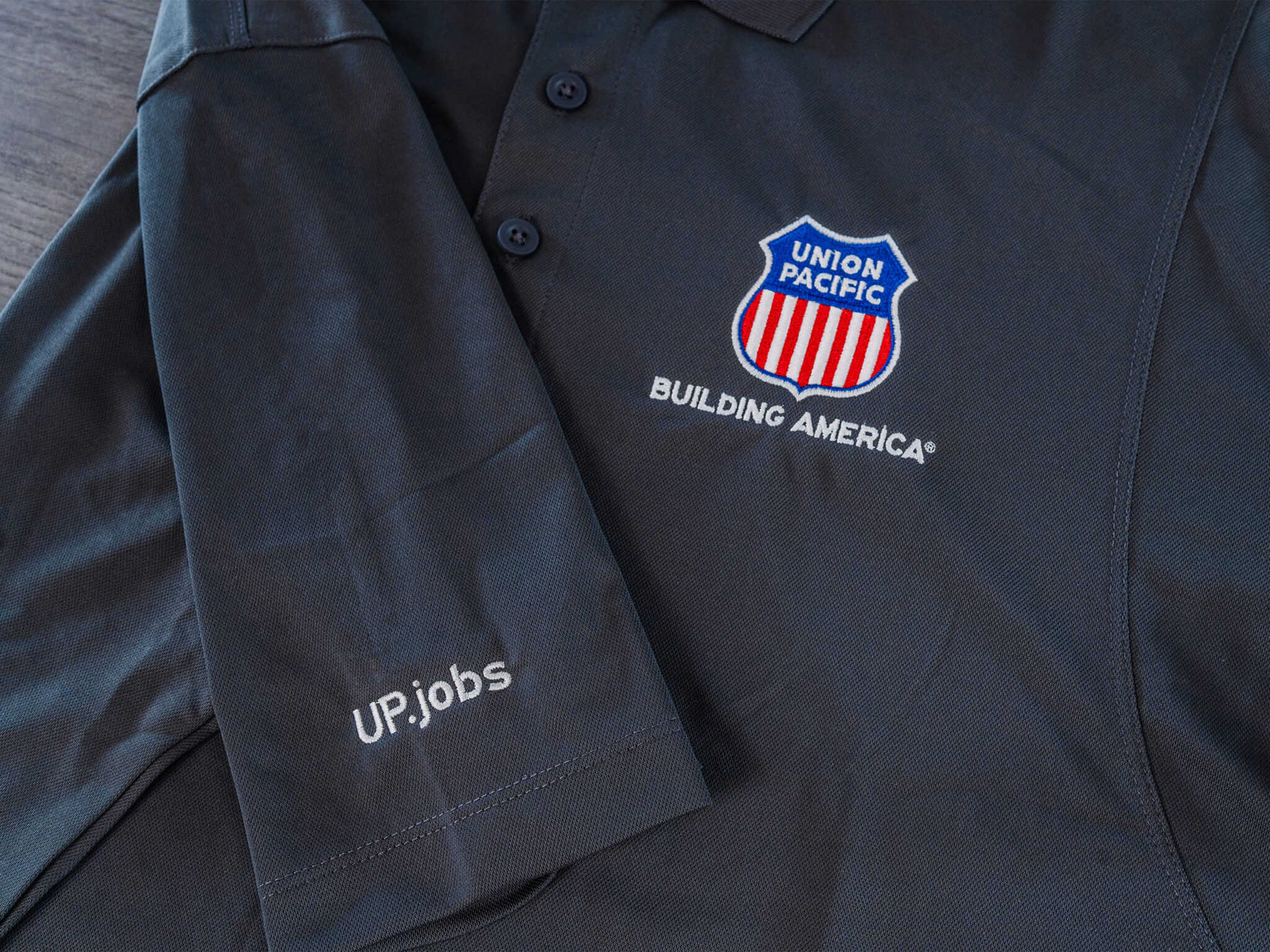 A black polo shirt with an american flag on it.