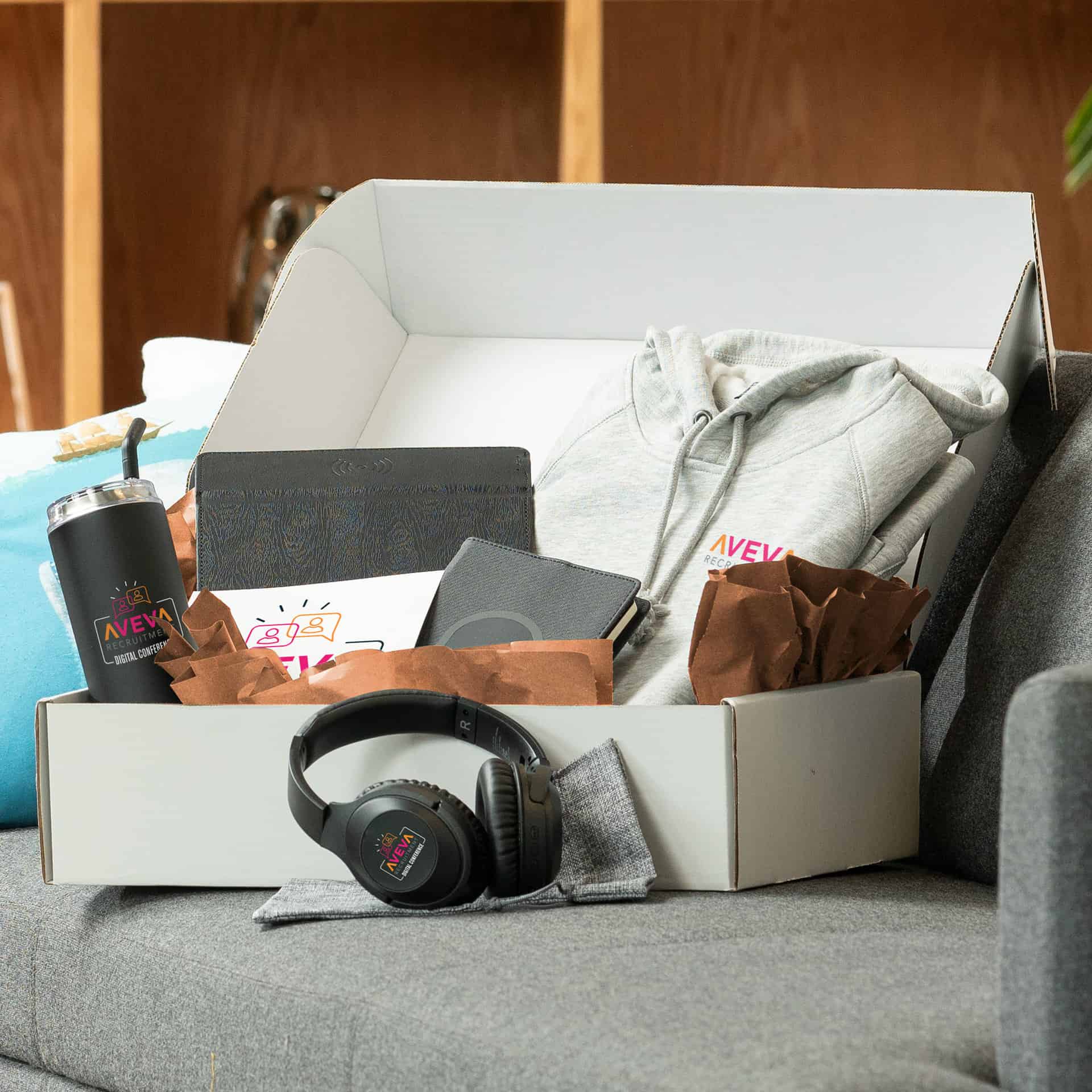 Promotional products box containing headphones and a hoodie, alongside other items.